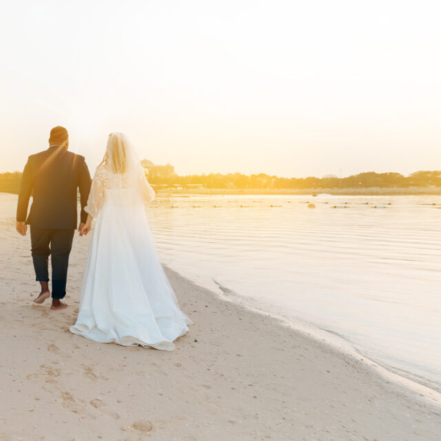 wedding-beach-holding-hands-back-pose-sunflares-romantic